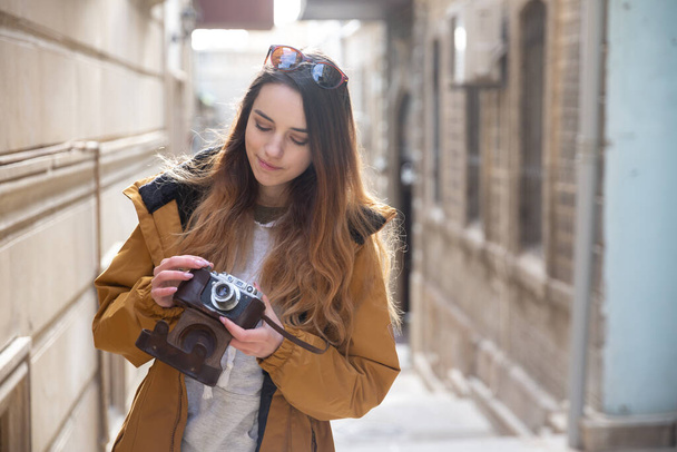 Photo d'une jeune touriste explorant les rues de Bakou. Moody photos d'adolescente visitant la vieille ville et prenant des photos de la ville
. - Photo, image