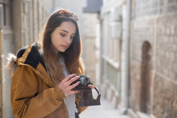 Fotografie mladé turistické dívky objevující ulice Baku. Moody fotky dospívající dívky na návštěvě starého města a fotografování města. - Fotografie, Obrázek