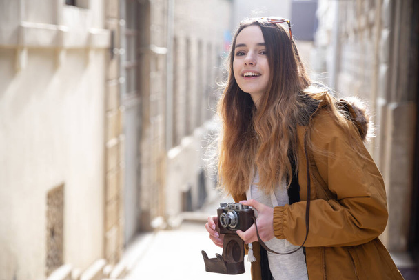 Фото молодої туристичної дівчини, що досліджує вулиці Баку. Муді фотографії дівчини-підлітка, що відвідує старе місто і фотографує місто.. - Фото, зображення