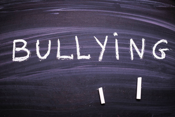 palabra bullying está escrito en la pizarra con tiza
. - Foto, imagen