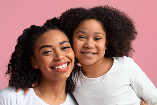 Zbliżenie Portret uśmiechniętej młodej czarnej kobiety z uroczą córeczką - Zdjęcie, obraz