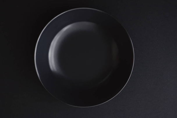 Empty plates on black background, premium dishware for holiday dinner, minimalistic design and diet - 写真・画像