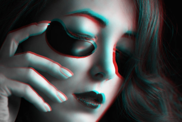 Beautiful young woman with fashion dark makeup and black under eyes hydrogel patches. Image with anaglyph stereo effect. - Photo, image