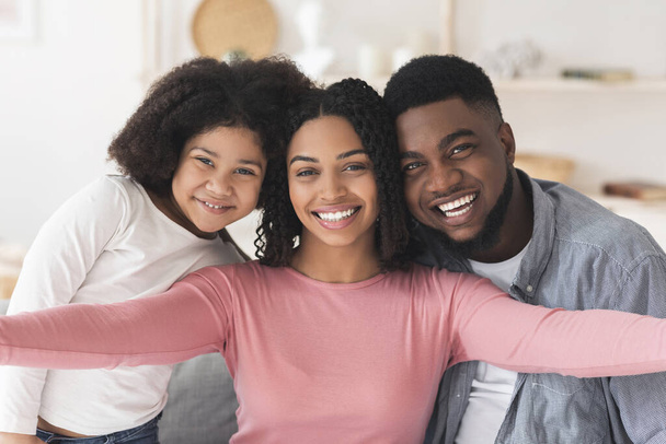 Positivo negro mujer tomando selfie con marido e hija en casa
 - Foto, Imagen