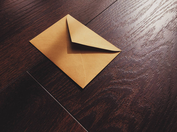 Golden vintage envelope on wooden background, newsletter and message - Photo, Image