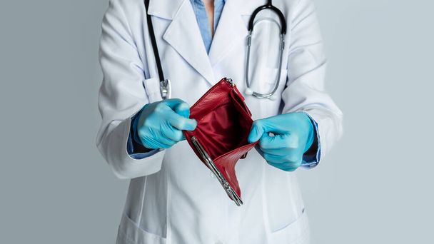 Krise in der Medizin. Arzt zeigt leere Brieftasche - Foto, Bild