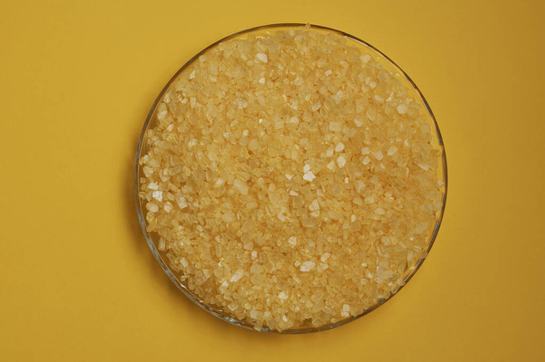 Κίτρινοι κρύσταλλοι αλατιού μπάνιου σε γυάλινο πιάτο για spa ή self-service - Φωτογραφία, εικόνα