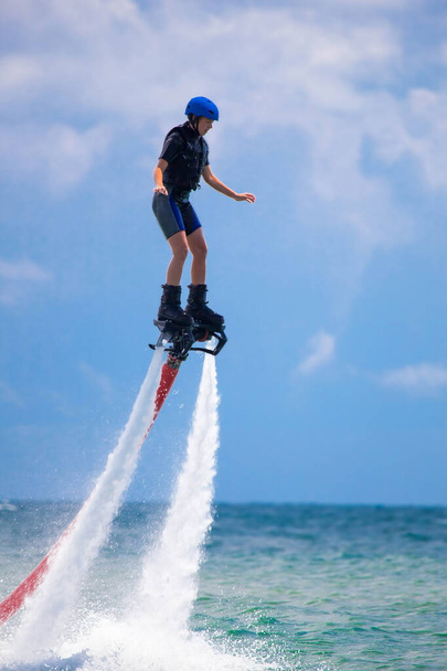 Young woman is flying at the aquatic flyboard. Water extreme sport - Photo, Image