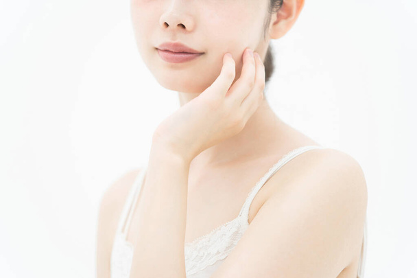 Азиатская (японская) молодая женщина, которая касается и проверяет свое состояние кожи
 - Фото, изображение
