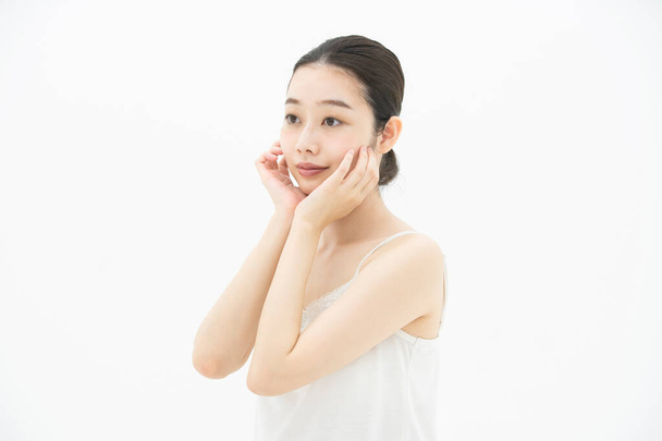 Une jeune femme asiatique (japonaise) qui touche et vérifie son état de peau
 - Photo, image