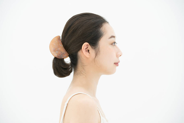 Eine asiatische (japanische) junge Frau, die ihren Hautzustand anfasst und überprüft - Foto, Bild