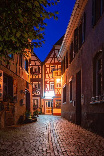Oude stadsstraat 's nachts in Wurzburg, Beieren, Duitsland. Lege steeg met lantaarns en traditionele Europese architectuur. - Foto, afbeelding