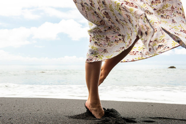 Ritratto laterale donna girando con abito sulla sabbia dalla spiaggia
  - Foto, immagini