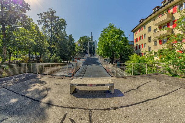 Βέρνη, Ελβετία - 30 Ιουλίου 2019: Ευρεία μεταλλική πεζογέφυρα στην οδό Lorrainestrasse της πρωτεύουσας. Πανοραμική. Θέα στην ηλιόλουστη μέρα του καλοκαιριού. - Φωτογραφία, εικόνα