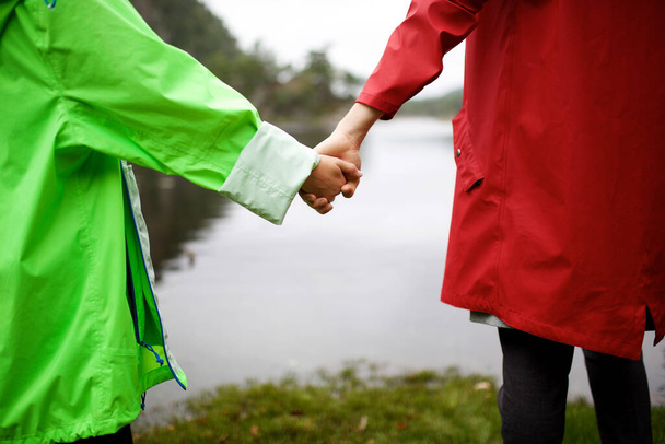 Muotokuva takaa tyttö ja nainen kädestä järven rannalla
  - Valokuva, kuva