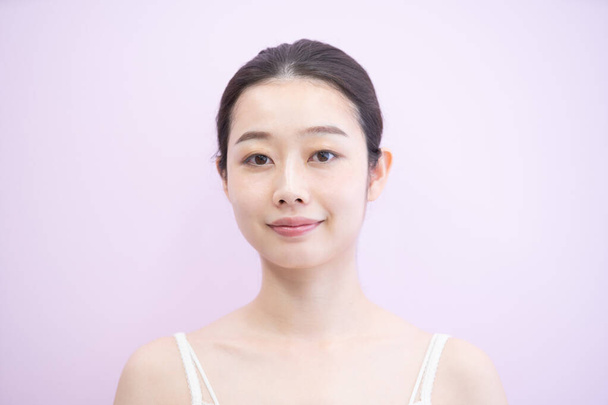 Молода жінка з Азії (японська), яка торкається і перевіряє стан шкіри. - Фото, зображення