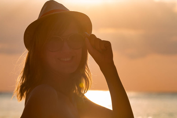 Silhouette egy lány élvezi az óceán / tenger partján naplementekor. - Fotó, kép