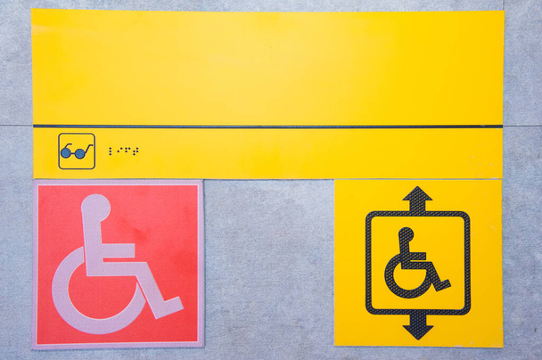 Mozgáskorlátozott segélyhívó gomb. sárga lemez egy fogyatékkal élő személy képével és egy hívógombbal. az emberi mozgás korlátozásának összetettsége. - Fotó, kép