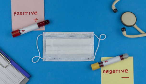 Flat lay composition with blood test tube and electronic thermometer on blue background. antiviral medical mask for protection against coronavirus COVID-19. negative and positive test. - Zdjęcie, obraz