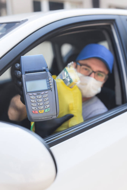 Delivery guy with protective mask and gloves delovering groceries during lockdown and pandemic. - Foto, imagen