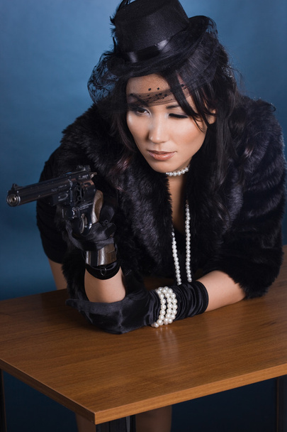 Elegant lady with a pistol in hands - Fotó, kép