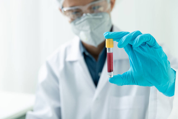 Исследователи проверяют образцы крови в лаборатории. Исследователи изобретают вакцины для лечения вируса COVID-19. - Фото, изображение
