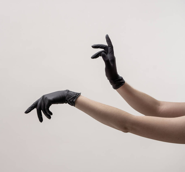 Hands in black silicone gloves on a light background. - Photo, Image