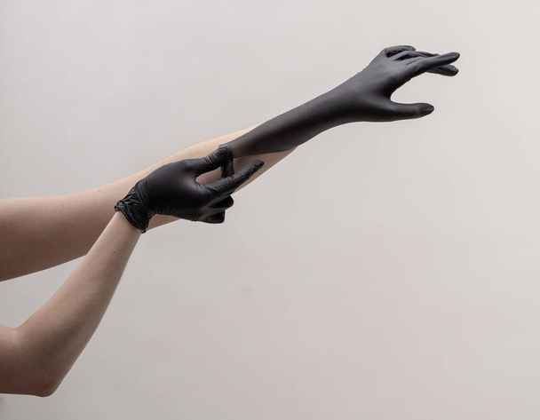 Hands in black silicone gloves on a light background. - Foto, Imagen
