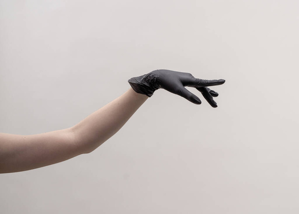 Aesthetic female hand in a black glove. - Фото, изображение