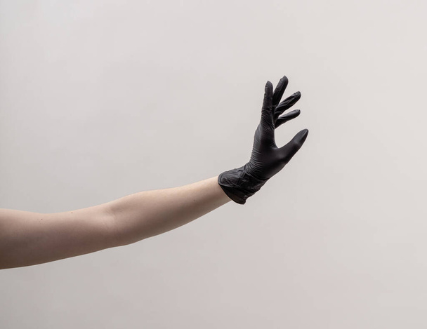 Aesthetic female hand in a black glove. - 写真・画像