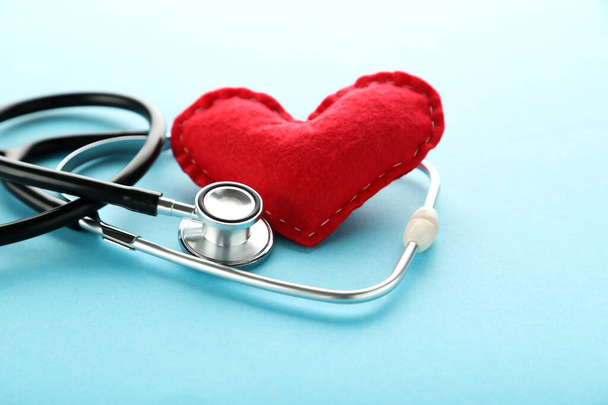Stethoscope with red fabric heart on blue background - Photo, image