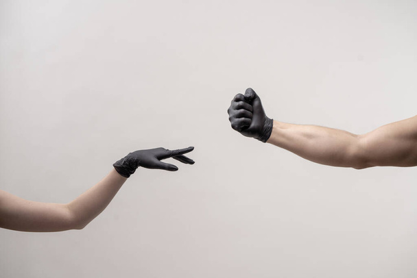 Hands in black silicone gloves stretches to each other to touch - Фото, изображение