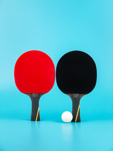 raquettes de tennis et une balle de ping-pong sur fond bleu
 - Photo, image