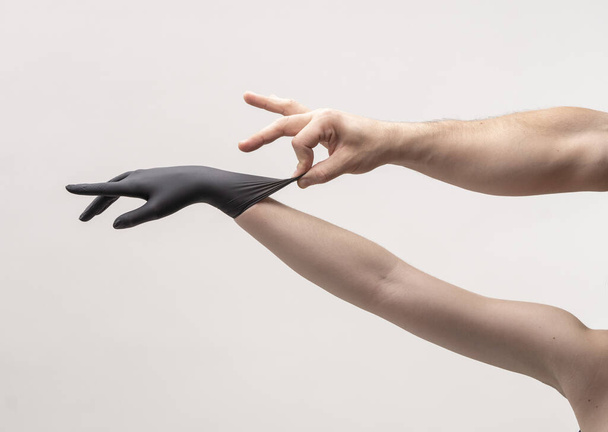 Female hand in a black silicone glove - Foto, imagen