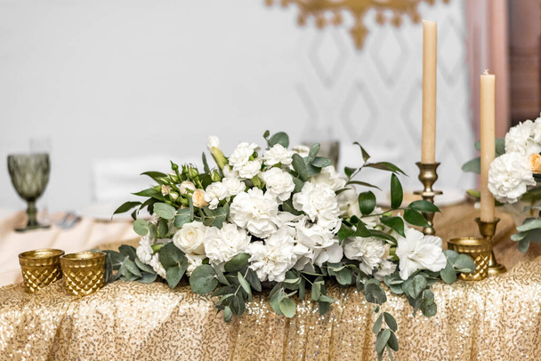 Weißer Hochzeitsstrauß auf dem Tisch im Restaurant. Hochzeitsbankett-Dekoration. Tische im Restaurant mit schönen weißen Pfingstrosen und Rosen dekoriert - Foto, Bild