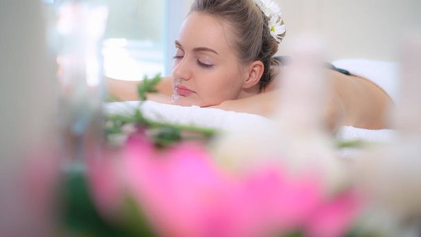 Mujer recibiendo tratamiento de masaje de piedra caliente por terapeuta esteticista profesional en el salón de spa. Bienestar de lujo, alivio del estrés de espalda y concepto de rejuvenecimiento. - Foto, imagen