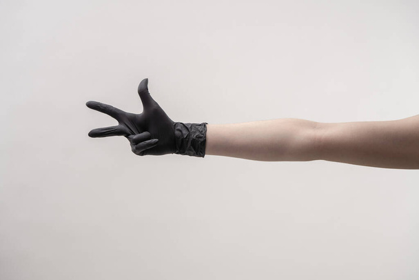 Hands in black silicone gloves on a light background. - Фото, зображення