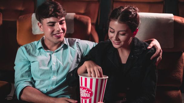 Miehet ja naiset syövät ja heittää popcornia oli hauskaa suuhunsa teatterissa - Valokuva, kuva