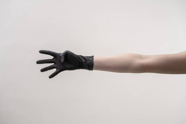Ruce v černé silikonové rukavice na světlém pozadí. - Fotografie, Obrázek