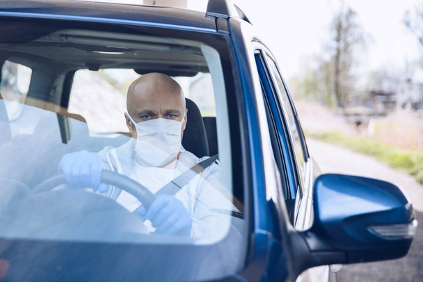 Man driving a car in medical protective mask. - Photo, Image