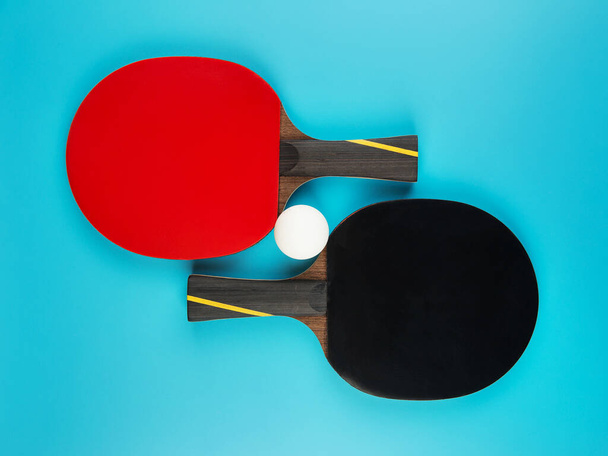 raquettes de tennis et une balle de ping-pong sur fond bleu
 - Photo, image