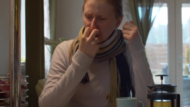 Молода жінка відчуває заблокований ніс під час холоду та грипу, розбризкуючи носовий спрей для лікування респіраторних захворювань. Ліки їй неприємні - вона замерзла і зітхає. Концепція охорони здоров'я та терапії
 - Кадри, відео
