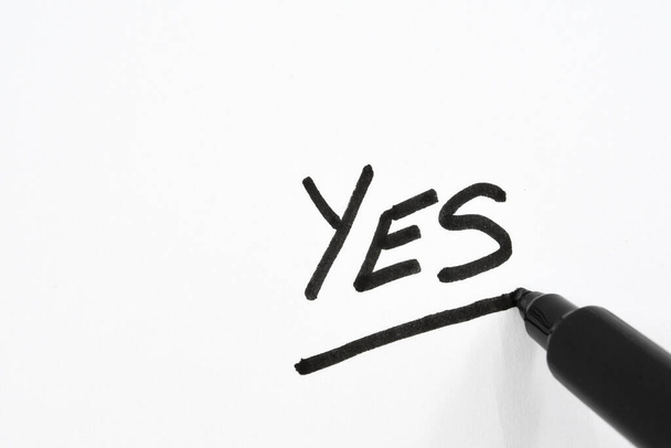 Vista ravvicinata di una penna a punta in fibra nera che sottolinea la parola "Sì" su carta bianca
 - Foto, immagini