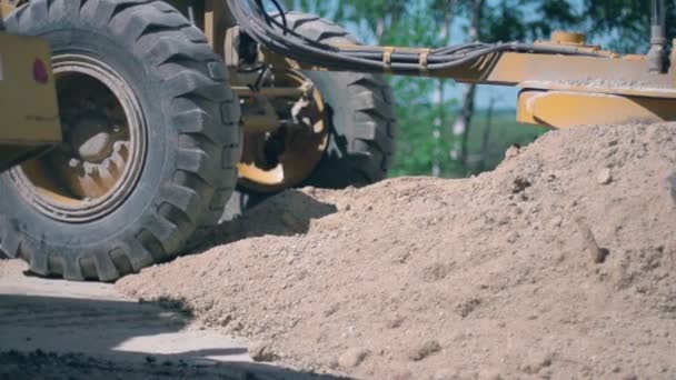Cesta funguje. Traktor vyrovnává půdu ve venkovské krajině. Zpomalený pohyb - Záběry, video