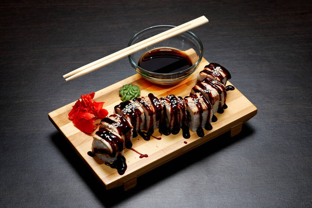 Smaczne i pyszne gorące i zimne bułki sushi na stole. Różne sushi - bułki z sosem na pokładzie kuchni japońskiej. - Zdjęcie, obraz