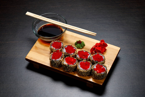 Smaczne i pyszne gorące i zimne bułki sushi na stole. Różne sushi - bułki z sosem na pokładzie kuchni japońskiej. - Zdjęcie, obraz
