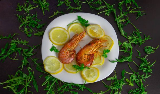 roasted prawns with lemon slices on a white plate and black background - Photo, Image