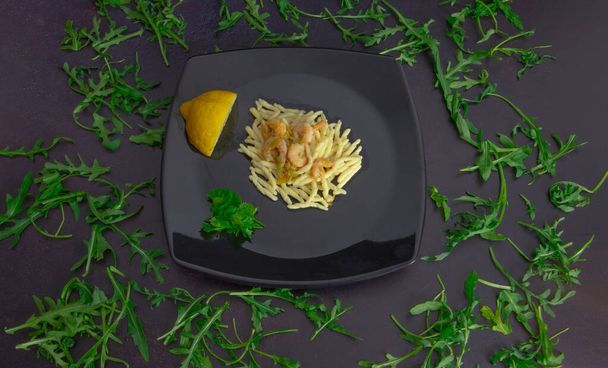 trofie con gamberi di zucchine e bottarga su piatto e fondo nero
 - Foto, immagini