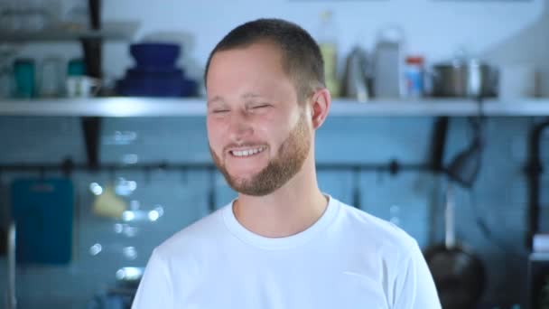 Portrait of happy good-looking guy smiling and looking at camera at home - Záběry, video
