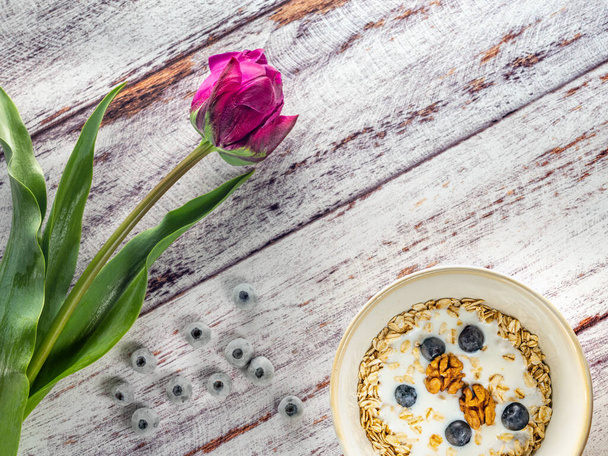 violet tulip and bowl with cereals and berries - Foto, Imagem